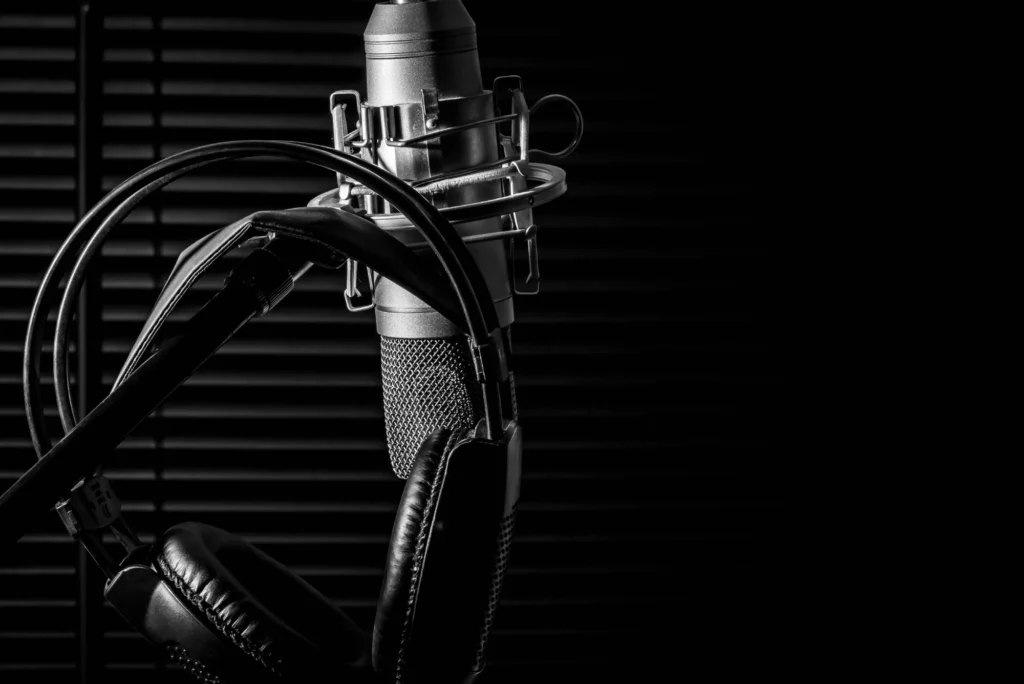 A microphone and headphones in front of a black background.